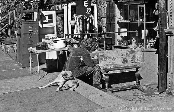 Homme et chien assis sur un trottoir